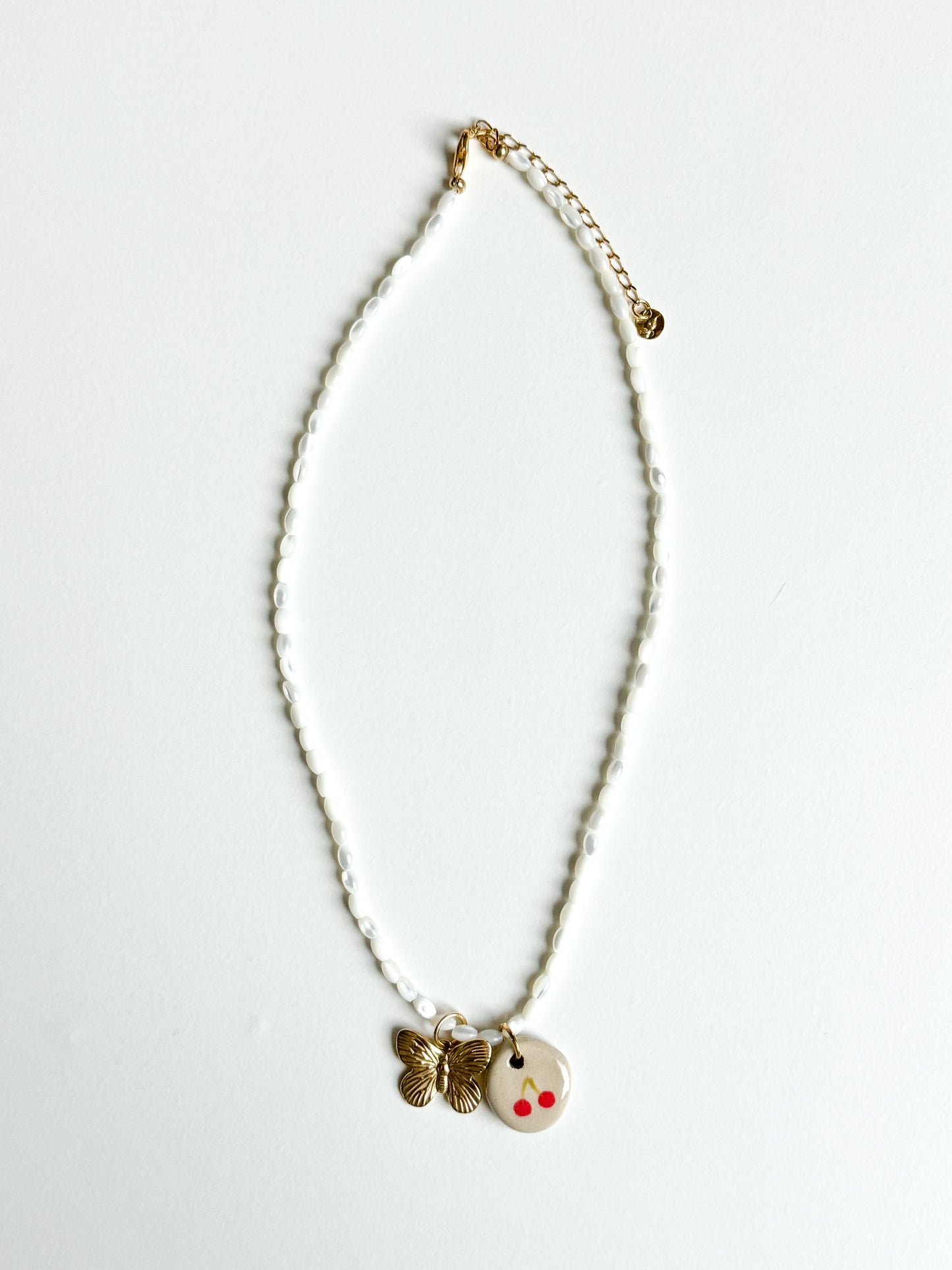 Collier cerise et papillon