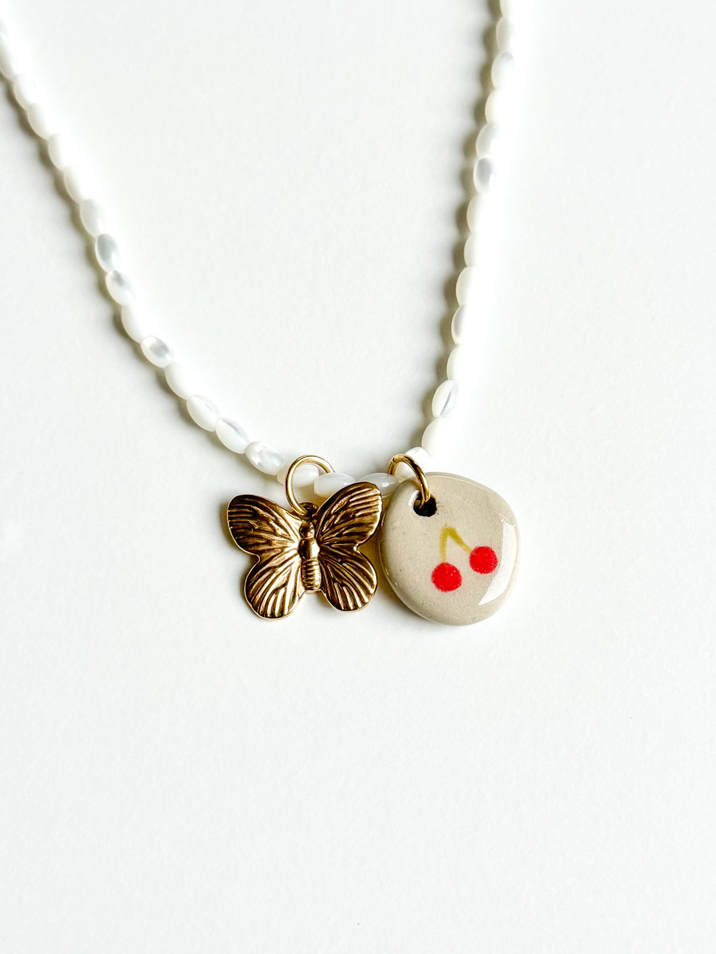 Collier cerise et papillon